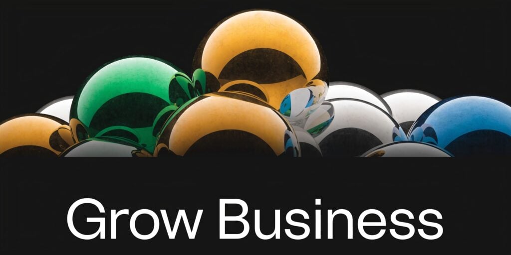 A collection of shiny, colorful metallic spheres arranged together above the white text Grow Business.